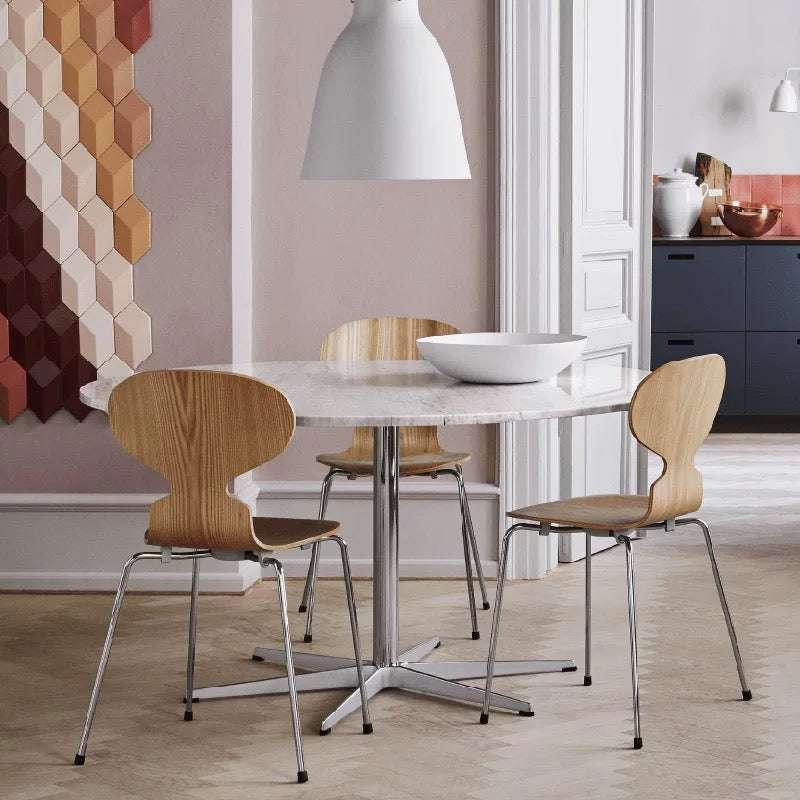 Dining area with a round marble table and wooden chairs in a modern interior setting.