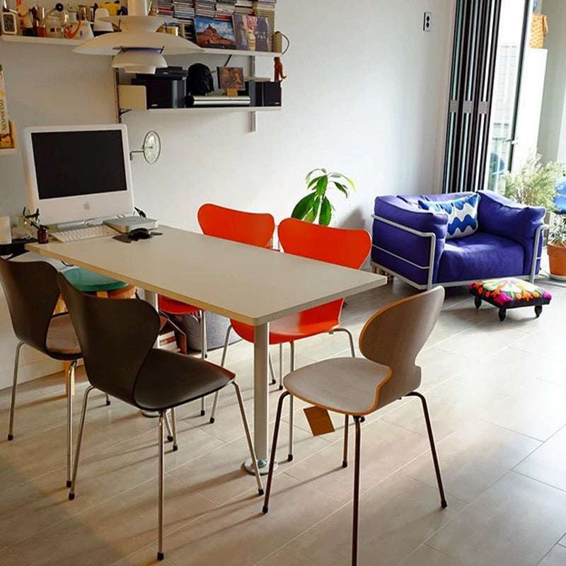 Modern office space with a desk, colorful chairs, and a blue sofa.