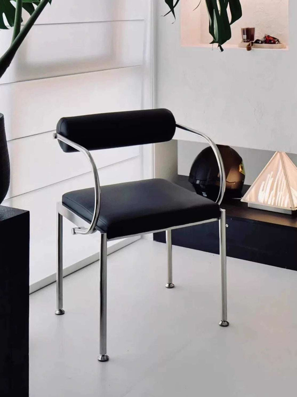 Black chair with chrome legs in a minimalistic room setting