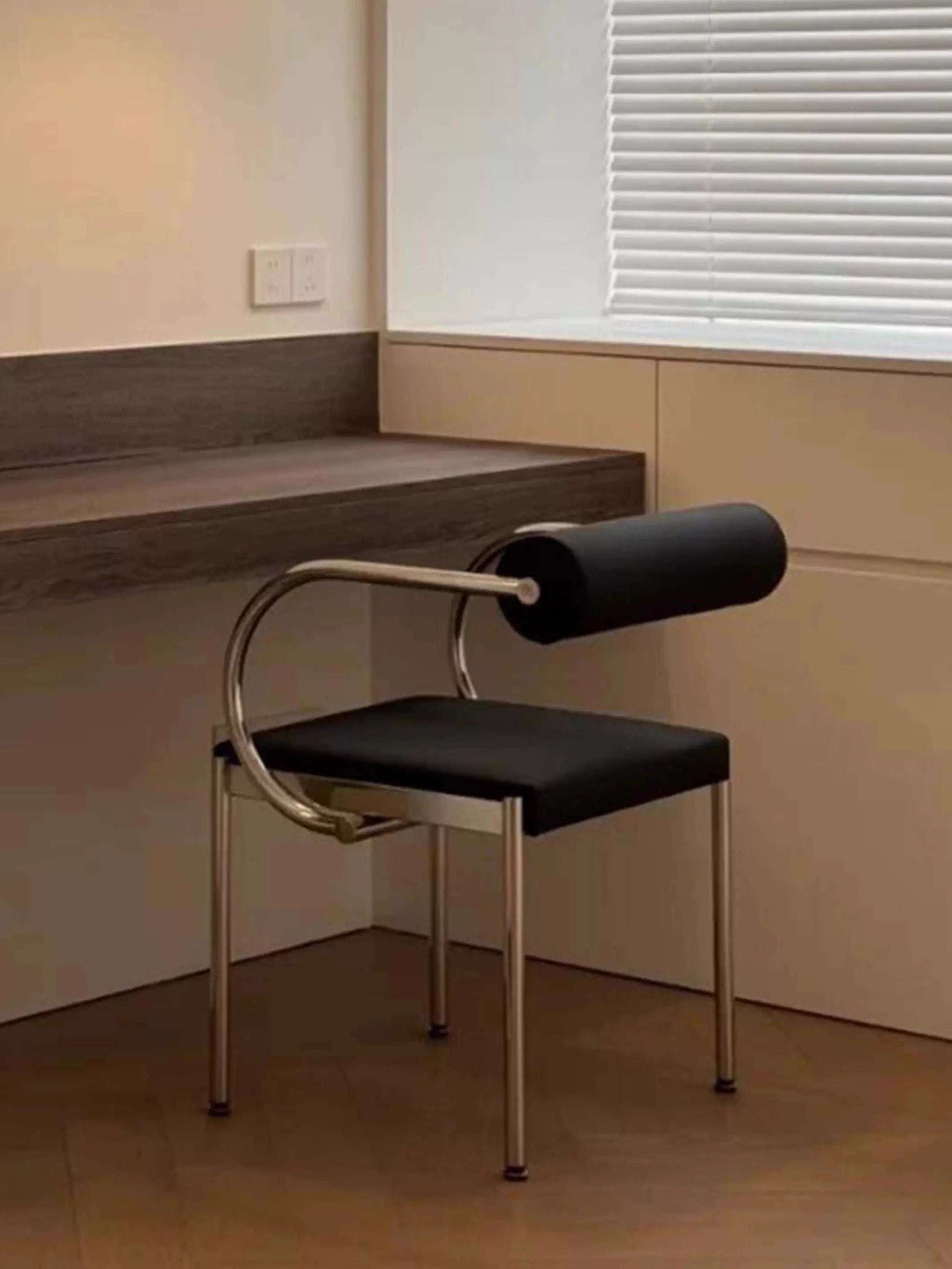 Modern black chair with metal frame in a minimalistic room.