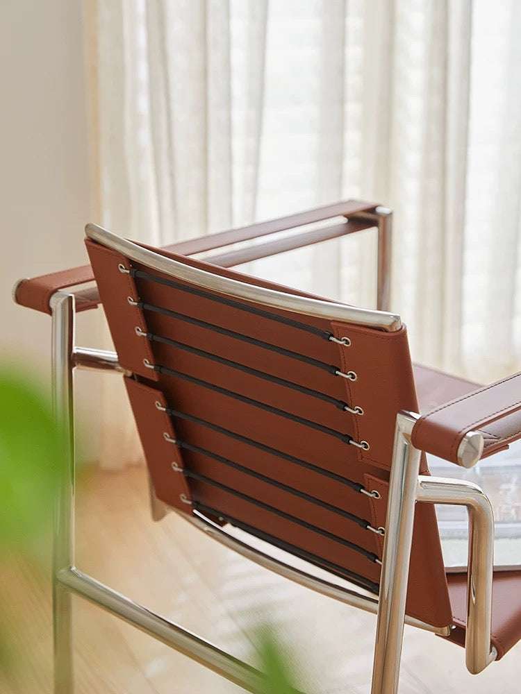 Brown chair with metal frame in a room with light-colored curtains