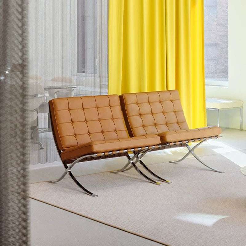 Modern brown leather bench with metal frame in a room with yellow curtains.