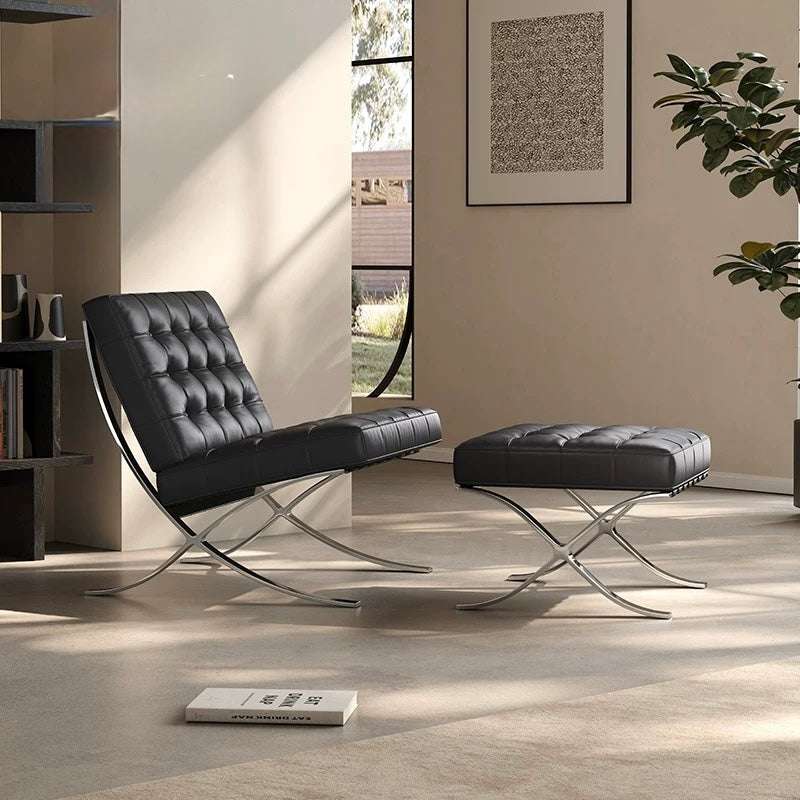 Modern black leather chair and ottoman in a stylish room with a book and plant.
