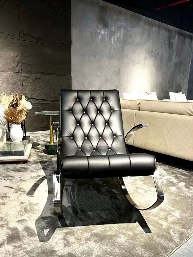Black leather armchair in a modern interior setting with a neutral color palette.