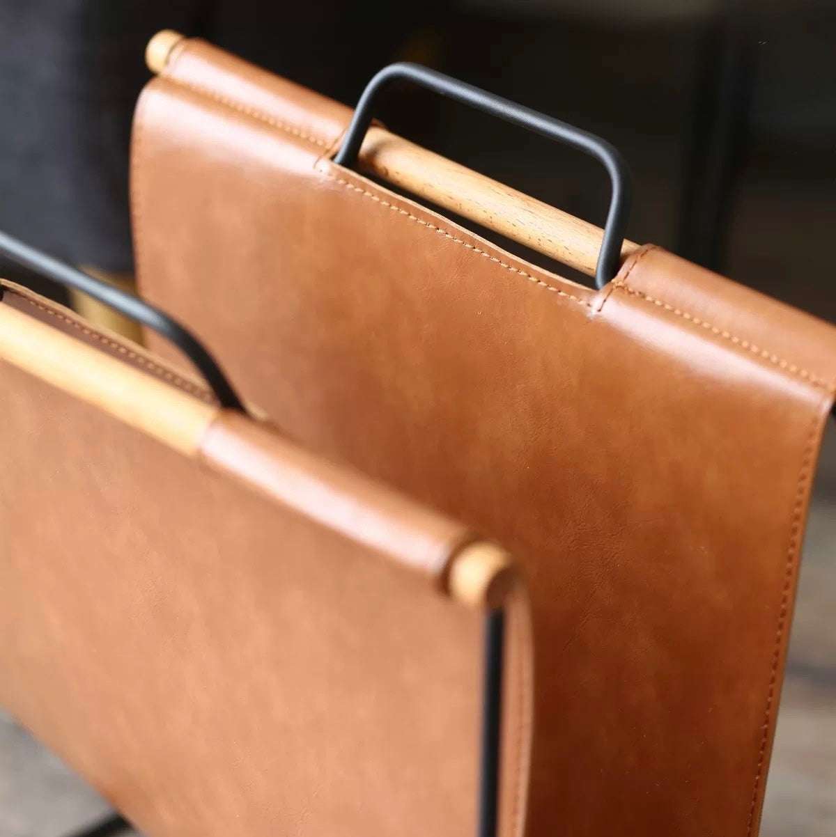 Close-up of a brown leather briefcase with gold accents on a blurred background