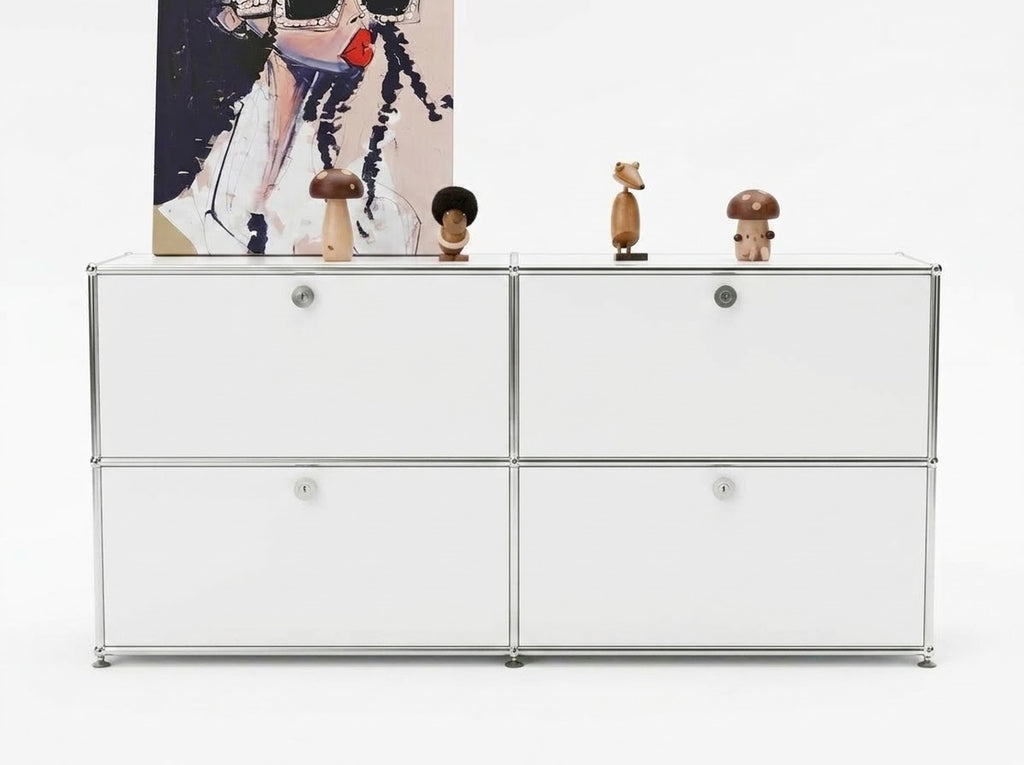 A white modular storage cabinet with a chrome metal frame and round silver knobs, styled with small decorative figurines and a framed print on top, set against a clean white background.