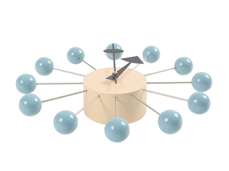 Modern wall clock with light blue spherical accents on a white background