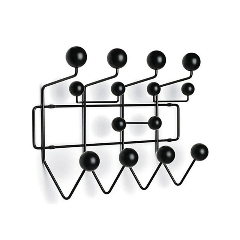 Black wall-mounted coat rack with round hooks on a white background