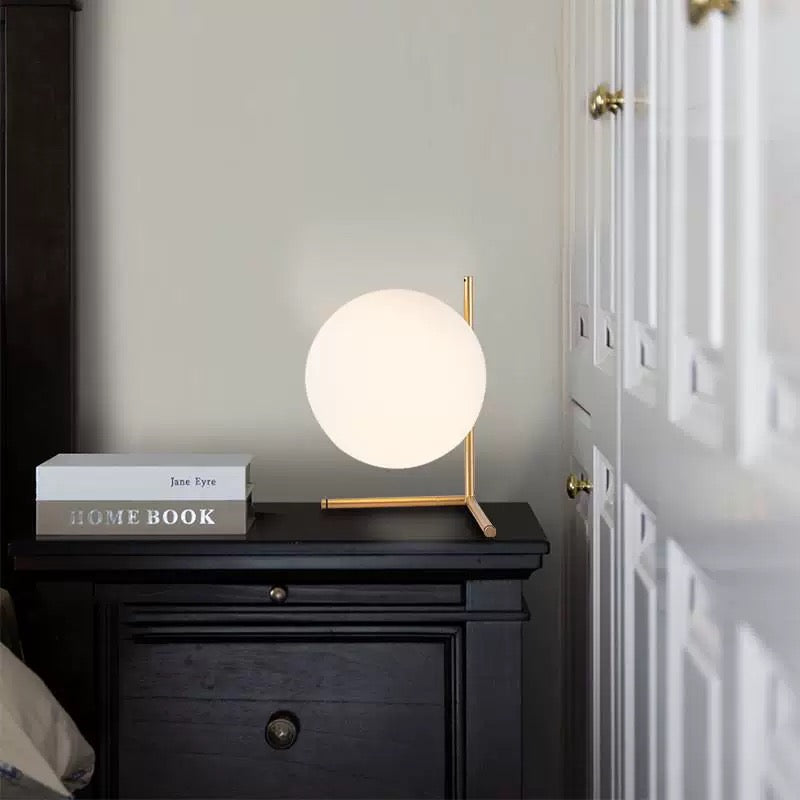 Table lamp on a nightstand next to a book with a home book cover