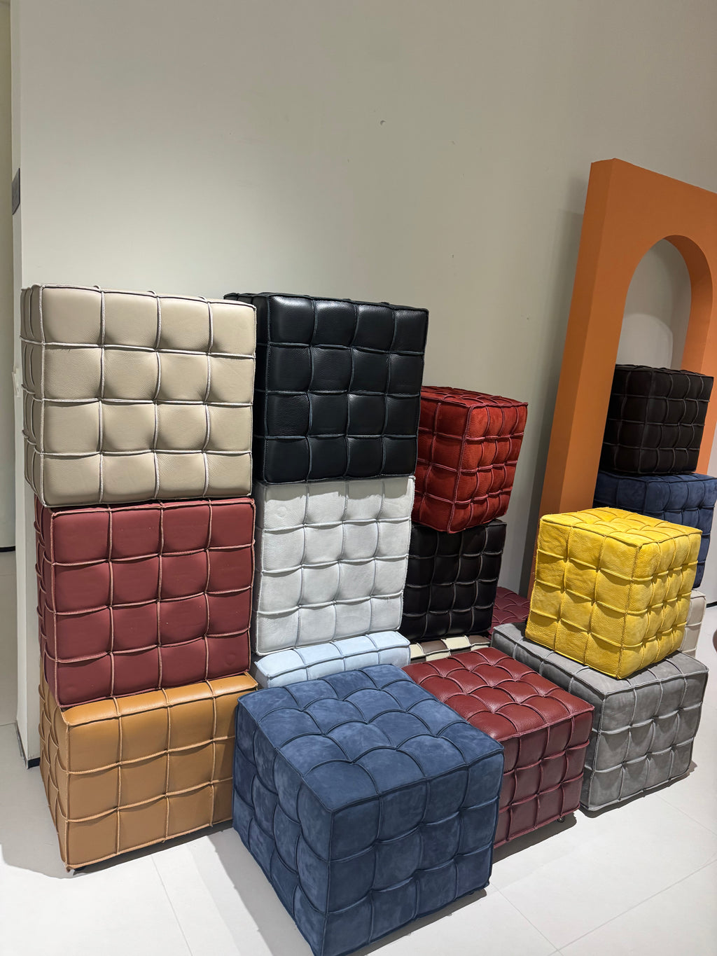 Colorful cube-shaped ottomans arranged against a neutral wall.