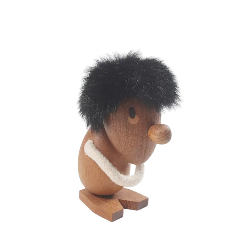 Wooden figurine of a character with black hair, brown body, and white rope on a white background