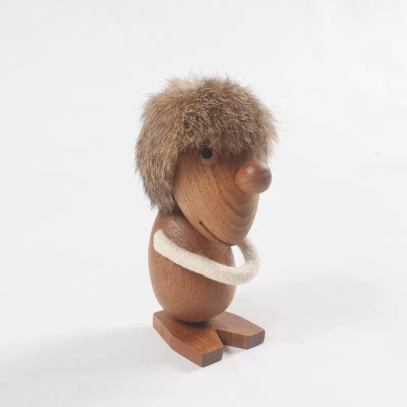 Wooden figurine of a creature with fur and a white ring on a white background