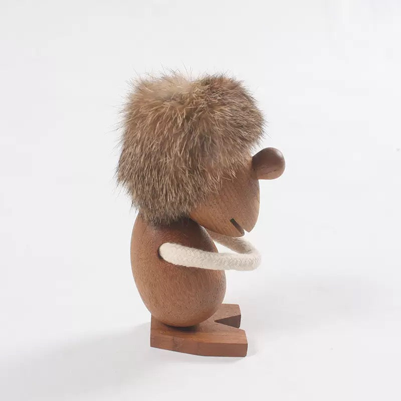 Wooden hedgehog figurine holding a white ring on a white background