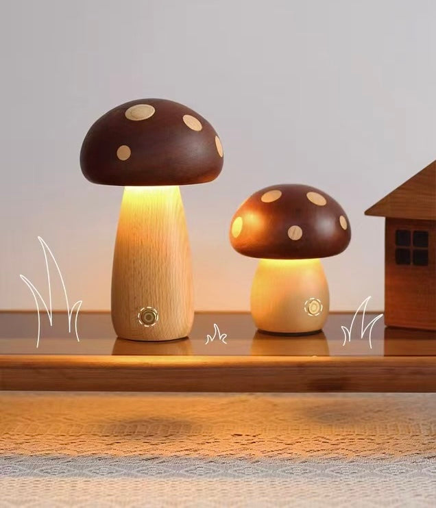 Two mushroom-shaped lamps on a wooden surface with a small house in the background.