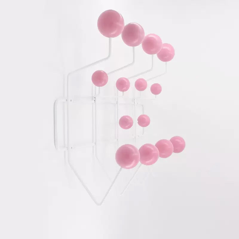 Pink hanging mobile with round elements on a white background