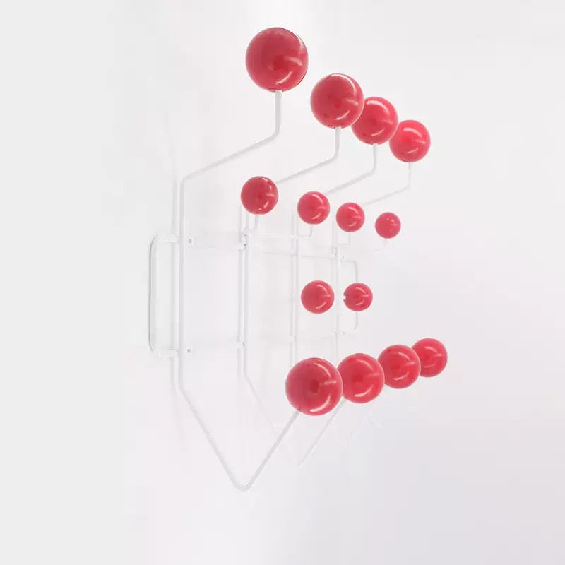 Decorative wall hanging with red spherical elements on a white background