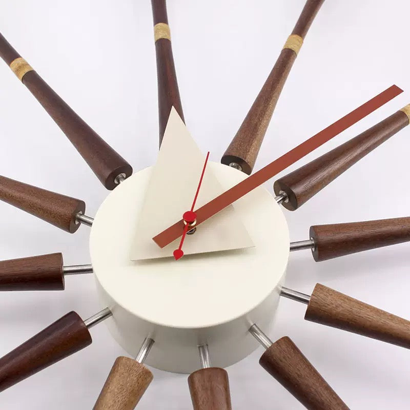 Modern wall clock with wooden spokes on a white background