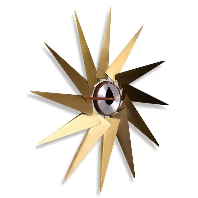 Decorative wall clock with starburst design in gold and bronze on a white background