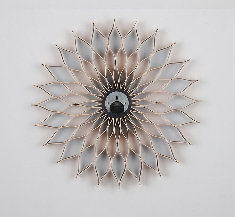 Decorative wall clock with sunflower design on a light gray background