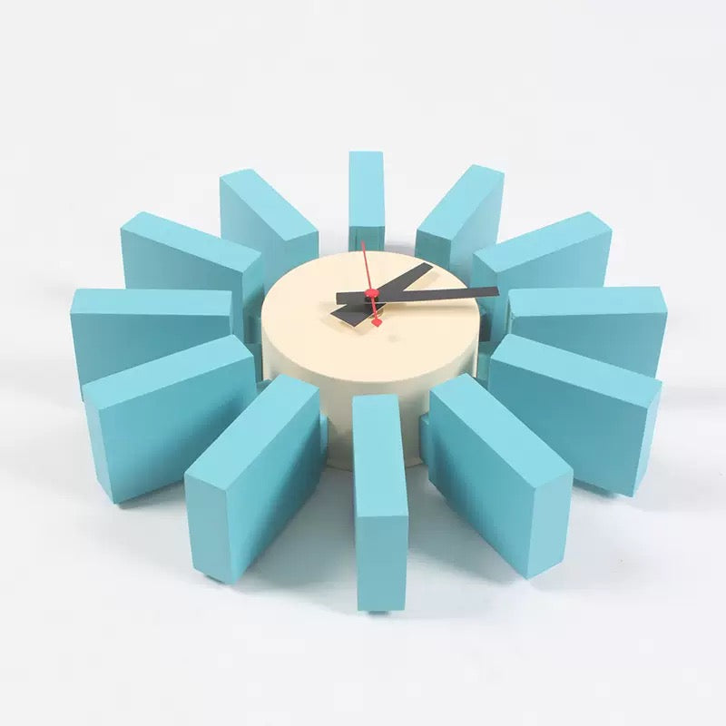 Modern wall clock with turquoise geometric design on a white background