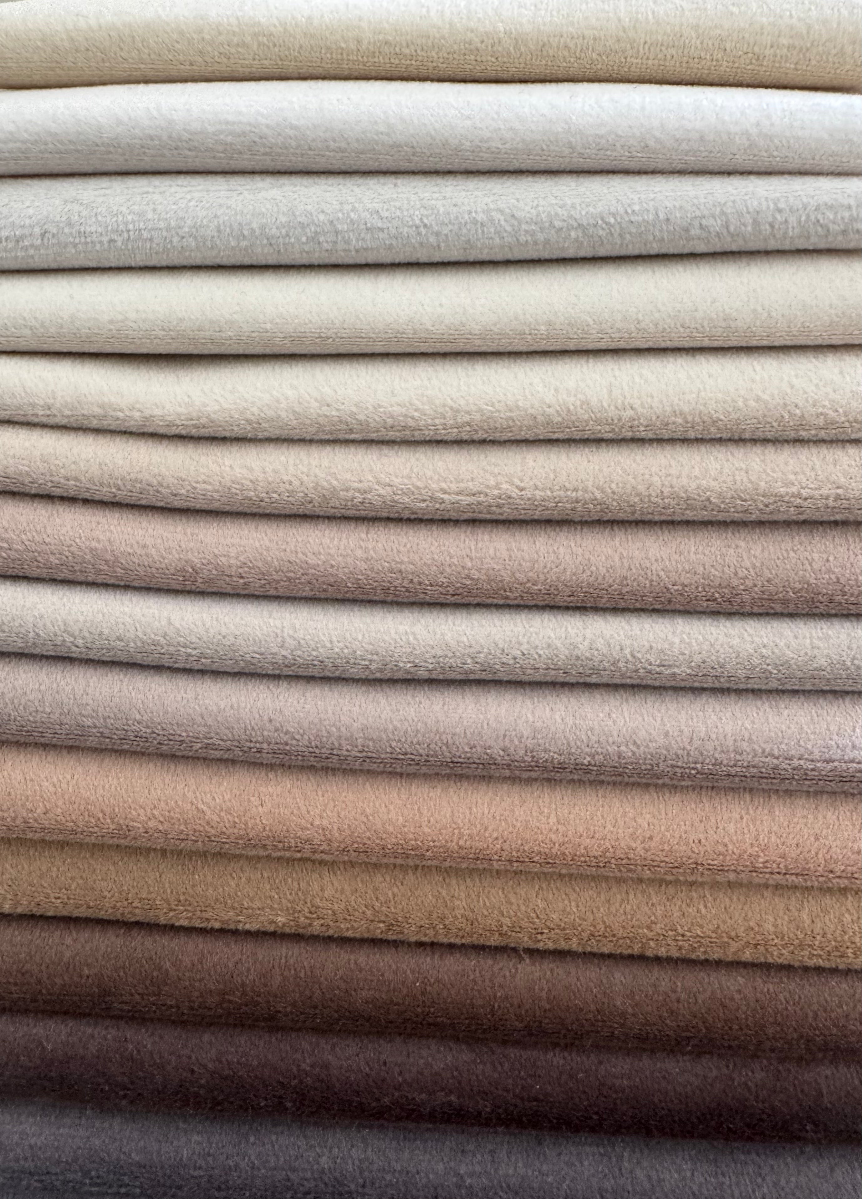 Stack of folded fabric swatches in various neutral colors.