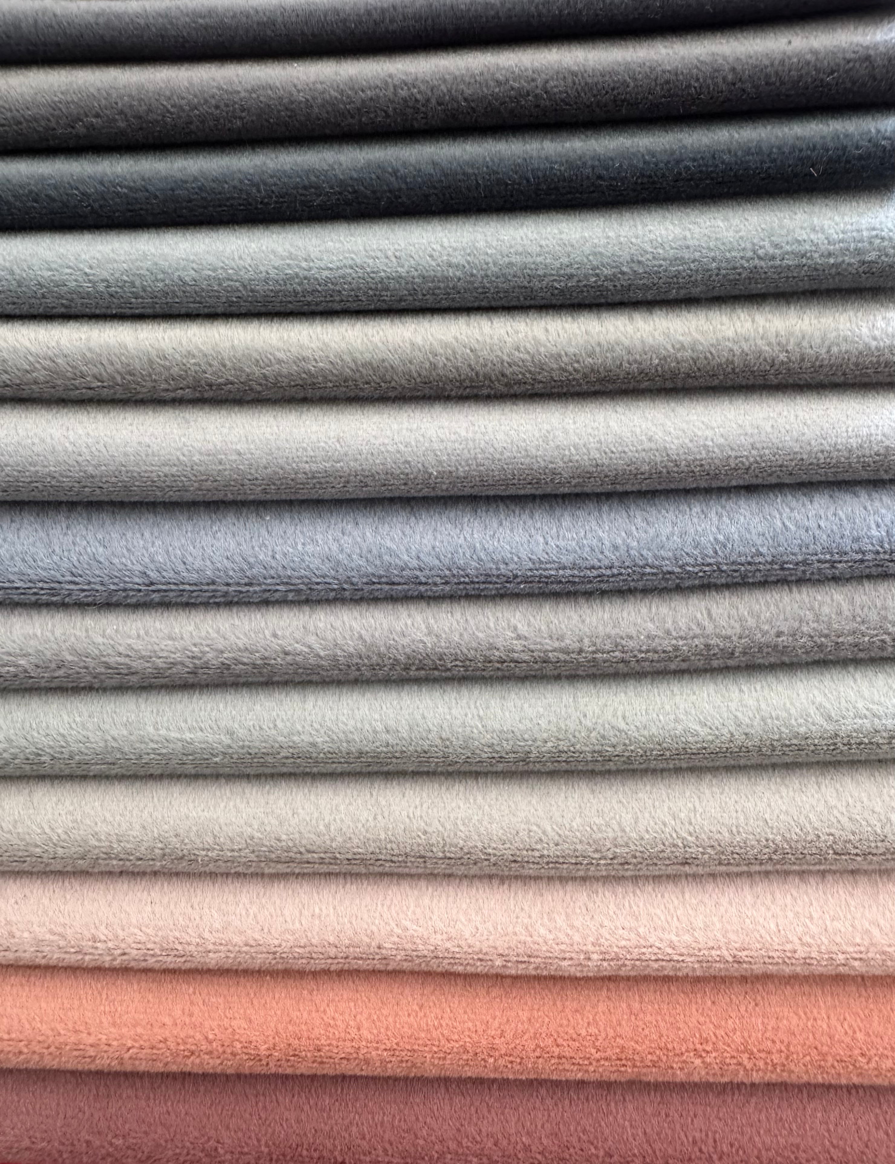 Stack of fabric swatches in various neutral colors.