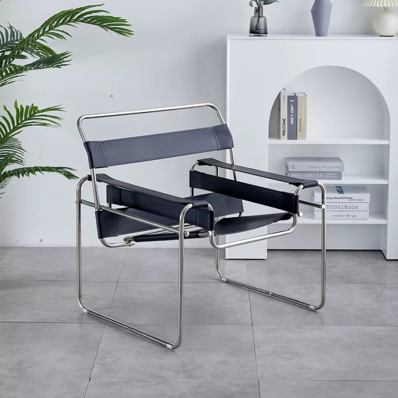 Modern chair with black leather straps in a room with a white bookshelf and plant.