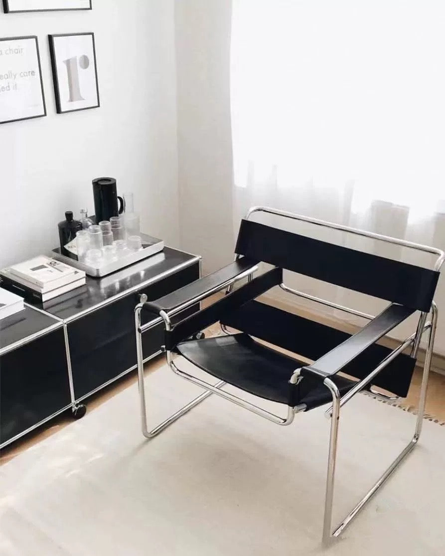 Modern black chair with chrome frame in a minimalistic room.
