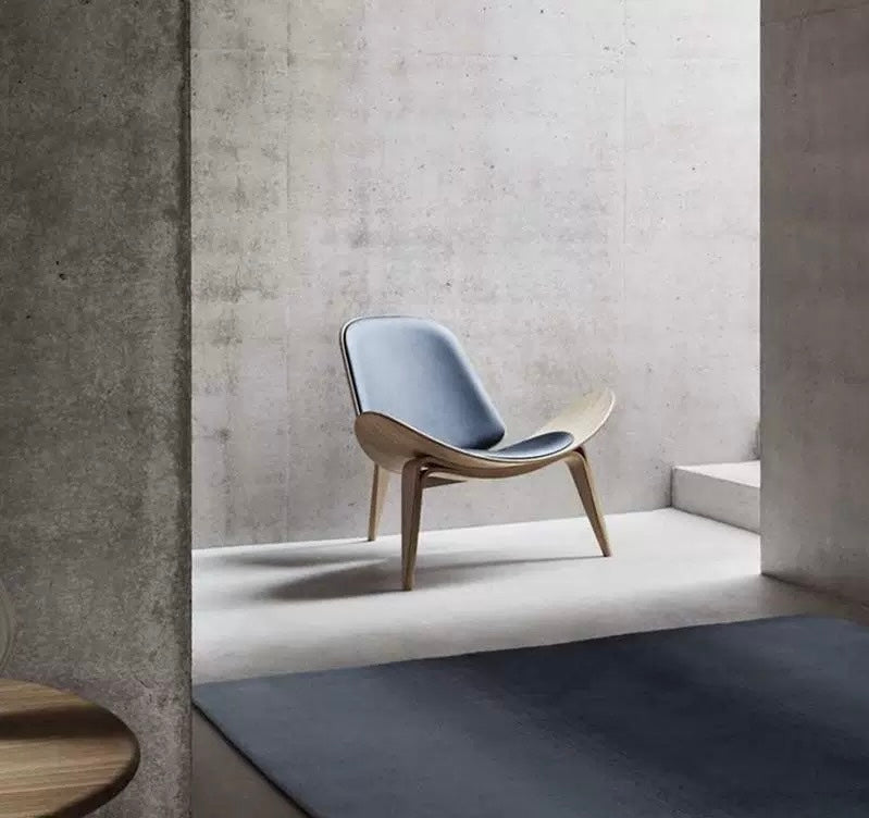 Modern chair with a concrete wall and gray floor in a minimalistic setting