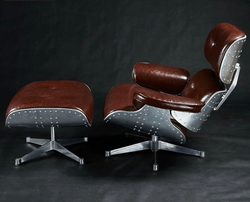 Brown leather chair and ottoman with silver base on a dark background