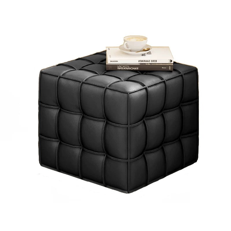 Black cube-shaped ottoman with dimensions and a book and cup on top.