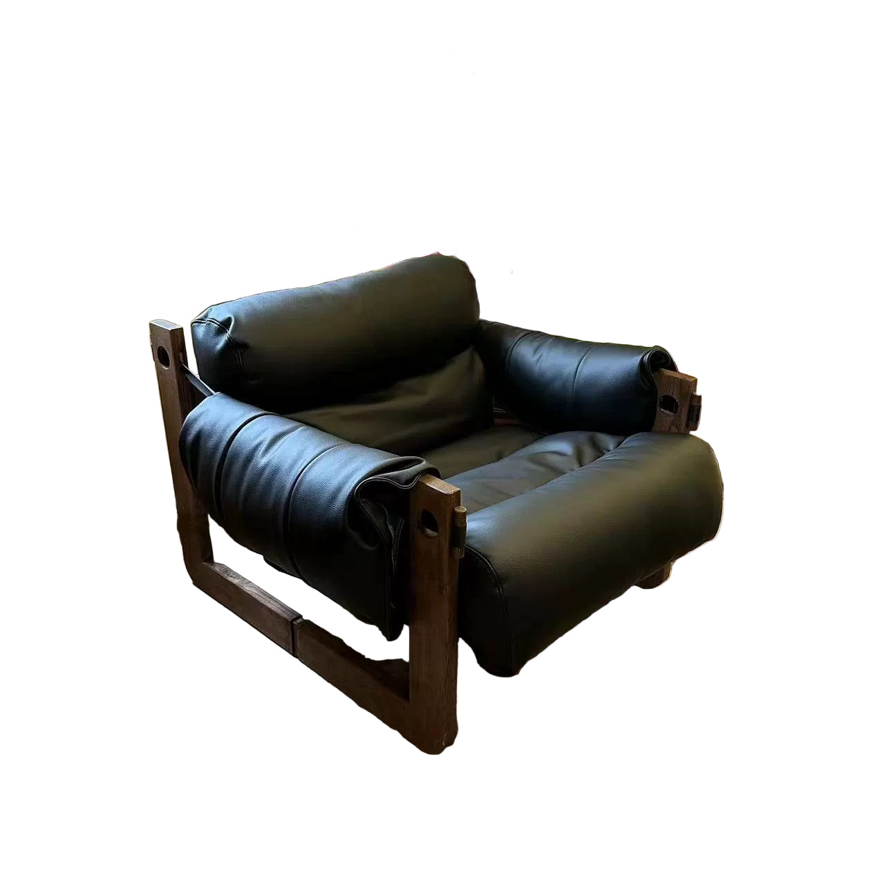 Black leather armchair in a room with wooden floor and decorative items.