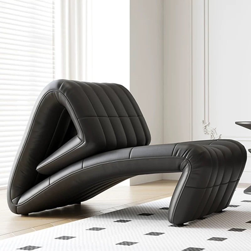 Modern black leather chair in a room with light-colored walls and a patterned rug.
