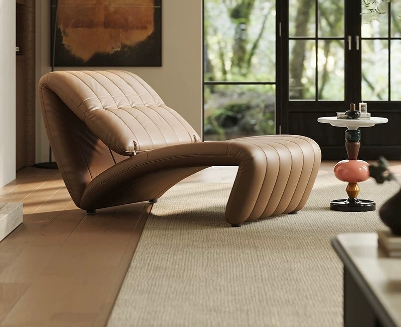 Modern beige lounge chair in a stylish room with large windows.