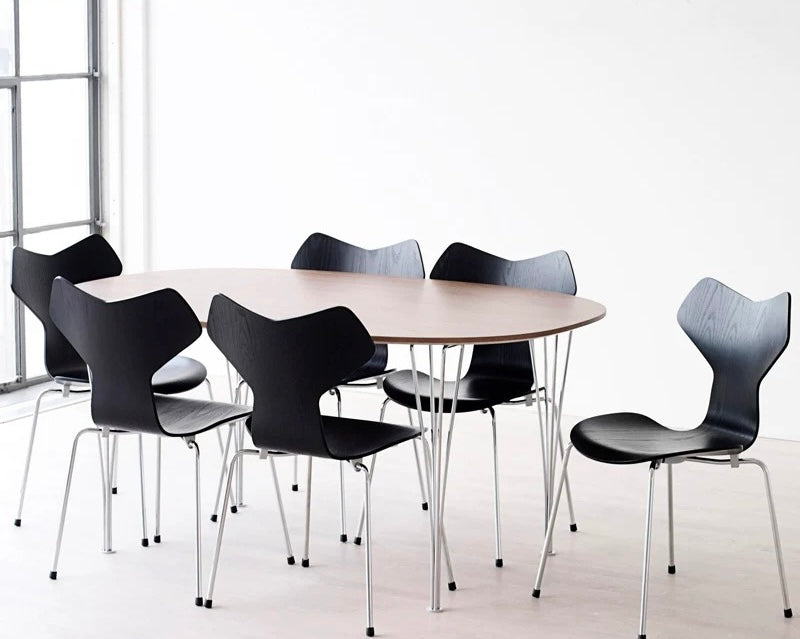 Round table with black chairs in a minimalistic setting