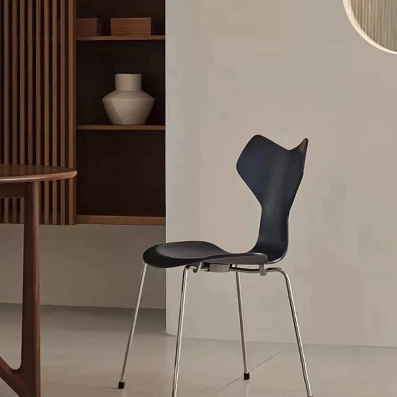 Modern black chair with metal legs in a minimalistic room.