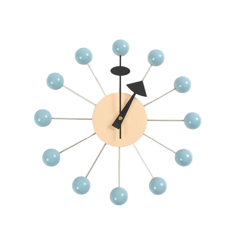 Modern wall clock with light blue spherical accents on a white background