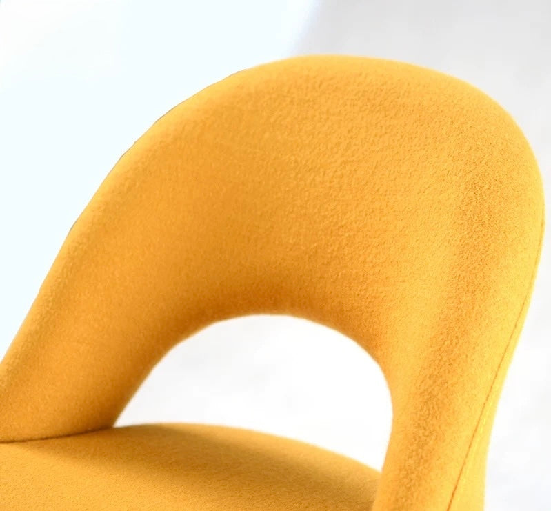 Close-up of a mustard yellow chair with a soft texture on a white background