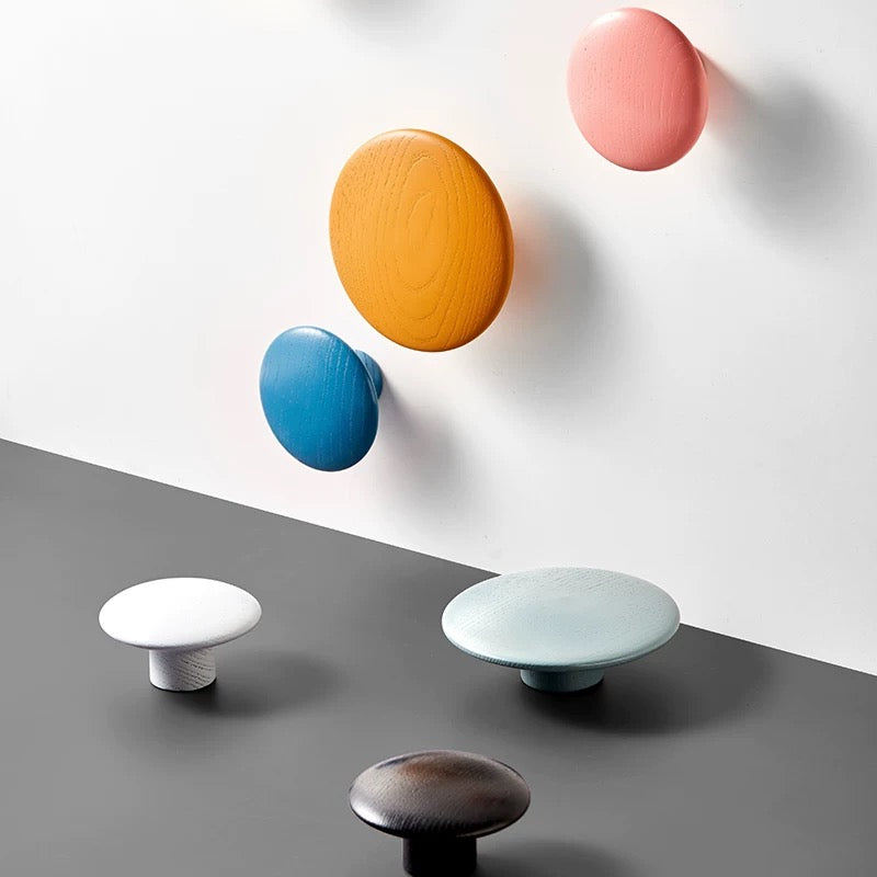 Colorful round wall hooks on a gray and white background