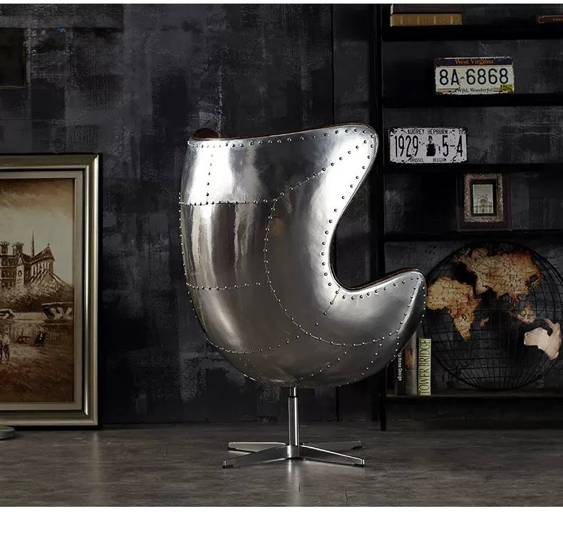 Metallic egg-shaped chair in a room with decorative elements.