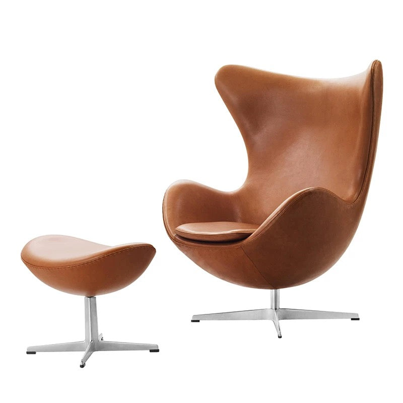 Brown leather egg-shaped chair with matching ottoman on a white background