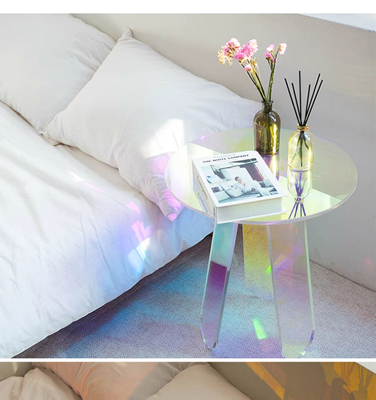 Iridescent side table with a book and vase on a bed